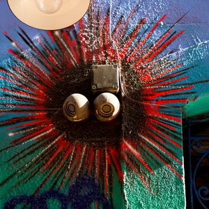Soleil dessiné autour de deux caméras utilisées pour représenter les yeux. - France  - collection de photos clin d'oeil, catégorie streetart